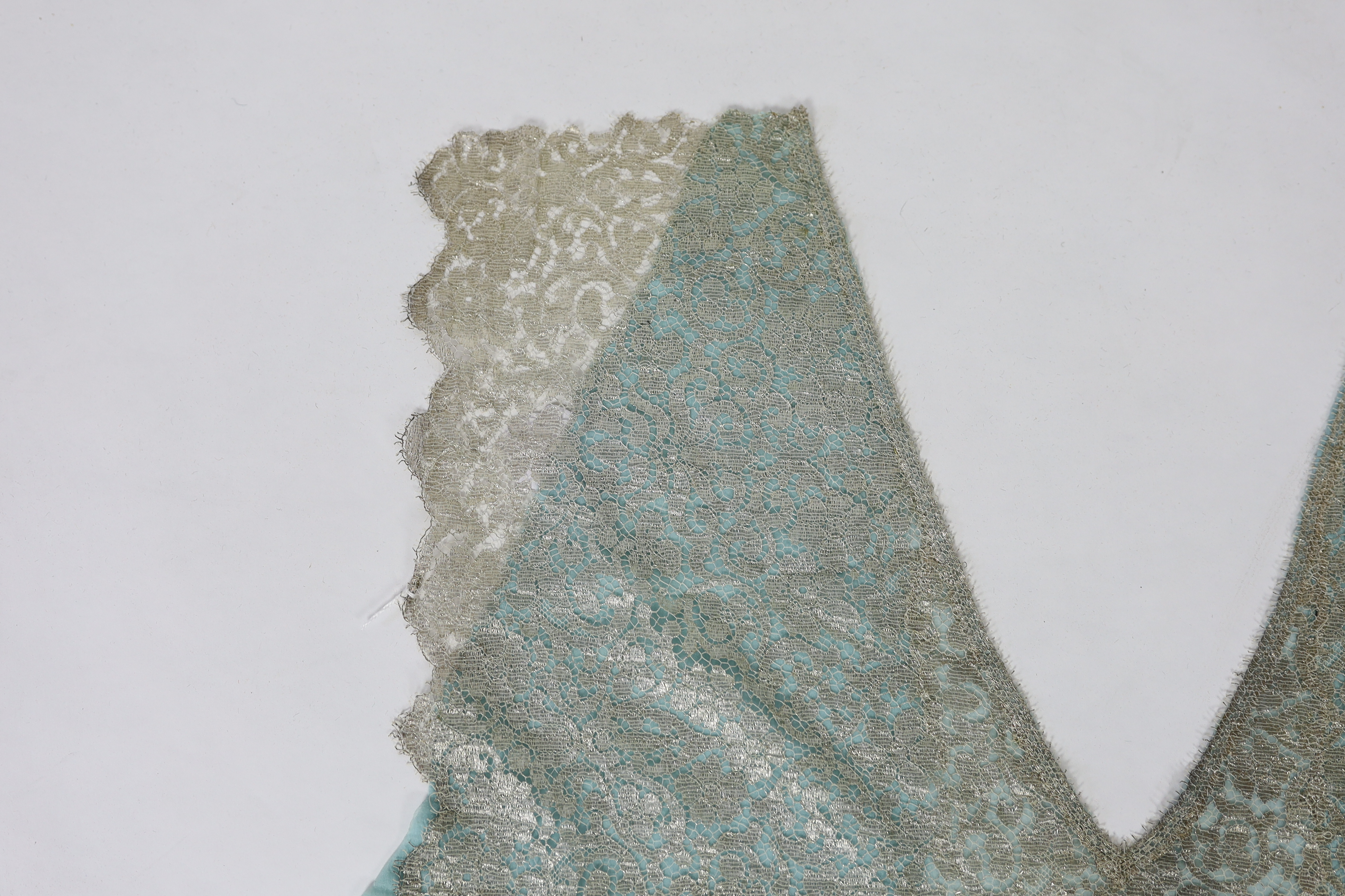 A 1920's silver machine lace and chiffon train, to an evening dress, the silver lace has been cut and appliquéd onto the turquoise chiffon, 209cm long